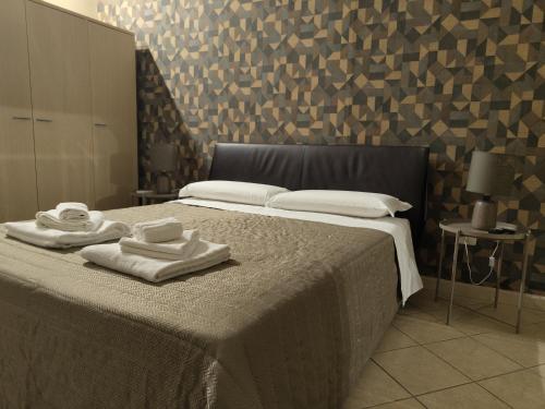 卡塔尼亚特里雅斯特酒店的一间卧室配有带毛巾的床