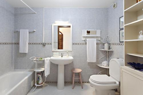 法鲁Apartamento Maresia的浴室配有盥洗盆、卫生间和浴缸。