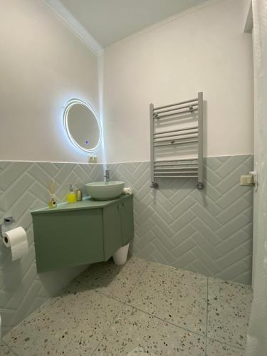 梅斯蒂亚Guesthouse SHAMPRIANI的一间带绿色水槽和镜子的浴室