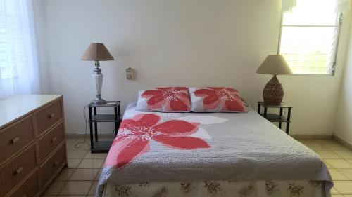 圣斐利-银港CASA BETTY COSTAMBAR的一间卧室配有一张带两个红色和白色枕头的床