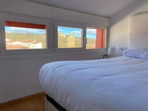 索里亚Vivienda turística Los Tejados的卧室配有白色的床和2扇窗户。