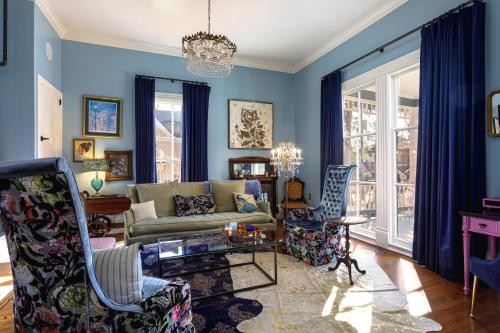彭萨科拉Celestine Bed and Breakfast的客厅拥有蓝色的墙壁,配有沙发和椅子