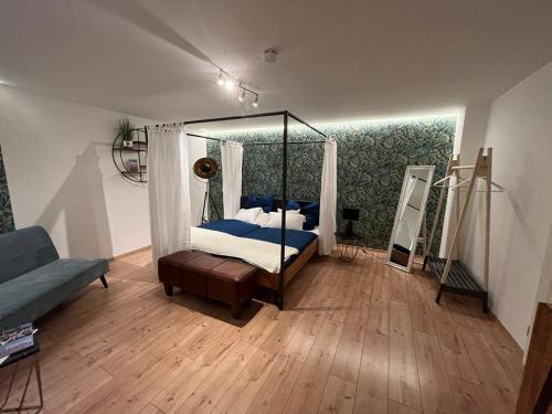帕绍Alte Schmiede的一间卧室配有天蓬床和沙发