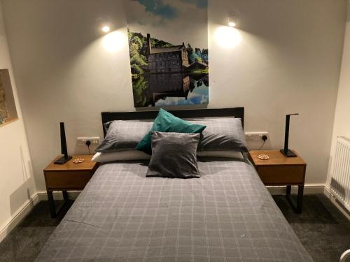 HeptonstallCoiners Rest的一间卧室配有带枕头的床铺和两张桌子