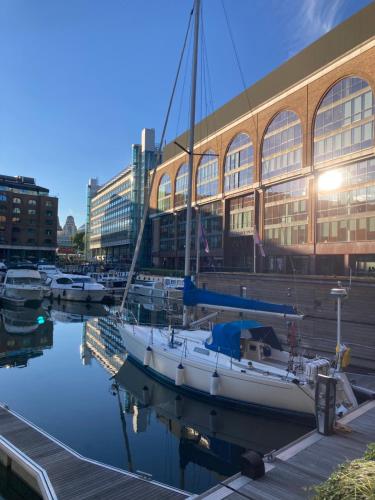 伦敦Entire Boat at St Katherine Docks 2 Available select using room options的停靠在大楼前的码头上的船只