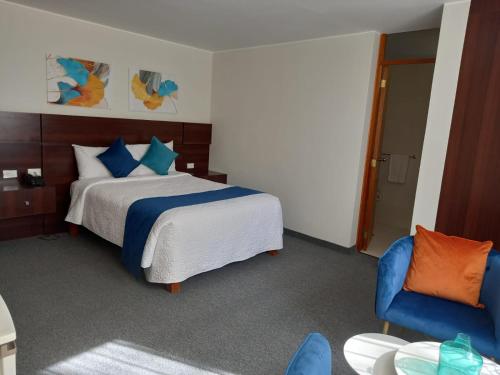 阿雷基帕Hotel La Gruta的一间卧室配有一张床和一张蓝色椅子
