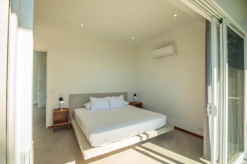 蒙特苏马Adeluna Luxury Villas的白色的卧室设有床和窗户