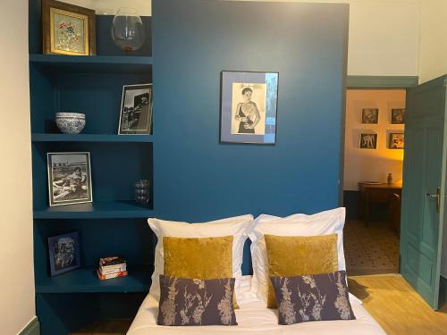 瓦朗斯Appartement Signature Art Déco的一间卧室拥有蓝色的墙壁,配有一张带枕头的床。
