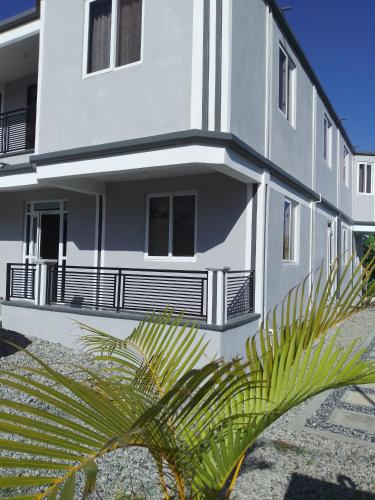 Paix Bouche2 Bedroom Residential Rental Unit的一座白色的建筑,前面有棕榈树