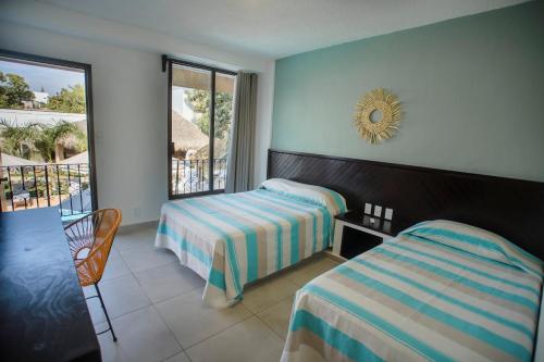 埃斯孔迪多港Hotel Camino Del Sol的酒店客房设有两张床和一个阳台。