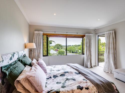 北哈夫洛克Busby Hill Villa - Havelock North Holiday Home的一间卧室设有一张大床和一个窗户。