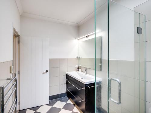 北哈夫洛克Busby Hill Villa - Havelock North Holiday Home的一间带水槽和玻璃淋浴的浴室