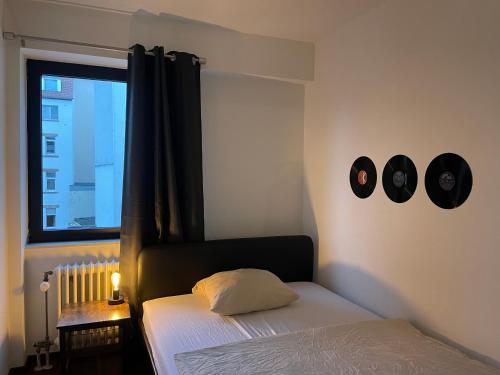 萨尔布吕肯Music Residence的一间卧室配有一张床,墙上挂着两个钟。