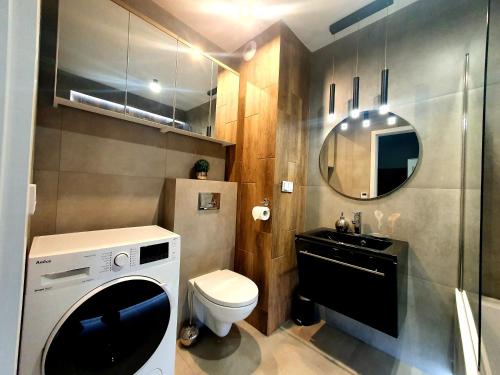 索斯诺维茨Konopnickiej 88 Cosy Apartment的一间带洗衣机和水槽的浴室