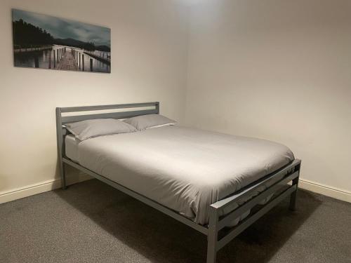 伦敦City Residencies - Thames View Greenwich的卧室内的一张床铺,墙上挂着一幅画
