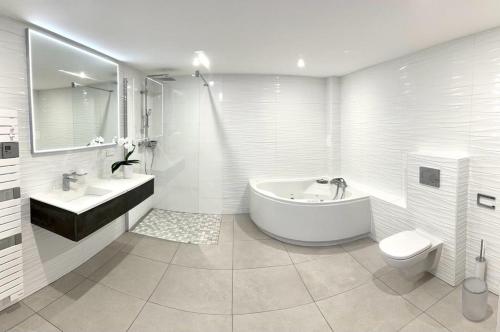 艾克塞恩维克斯Appartement Le Léman的白色的浴室设有浴缸、水槽和卫生间。