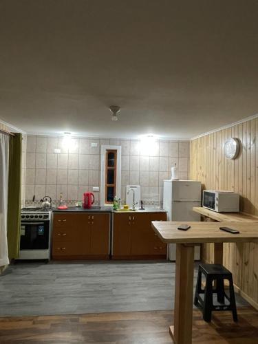 普孔Cabañas Rukafun 2的厨房配有木制橱柜和桌子。