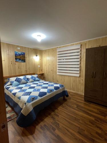 普孔Cabañas Rukafun 2的一间卧室配有一张带蓝白色毯子的床