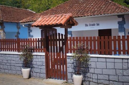 阿布拉奥Ilha Grande Inn的一座带木栅栏和建筑的房子