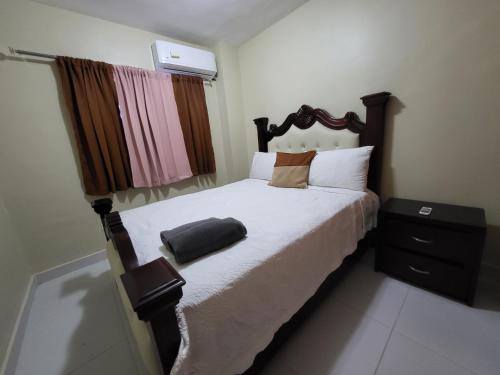 圣地亚哥洛斯卡巴Hermoso y comodo apartamento的一间卧室配有一张大床和木制床头板