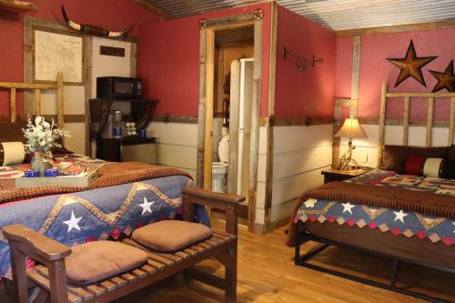 坎顿Acorn Hideaways Canton Cozy Frontier Suite 1890s Cattle & Land Decor的红色墙壁客房的两张床