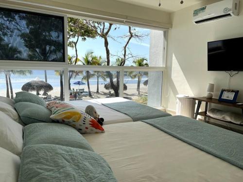 查梅Playa Caracol, beach happy的一间卧室设有三张床,享有海滩美景