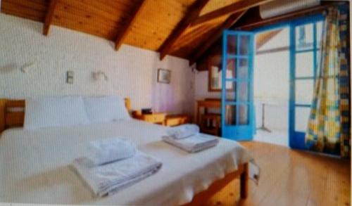 帕琉乔拉Exclusive Cottage in S West Crete in a quiet olive grove near the sea的一间卧室配有一张床,上面有两条毛巾