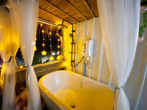 清刊ดูดาวแคมป์ริมโขง的一间带黄色浴缸和窗户的浴室