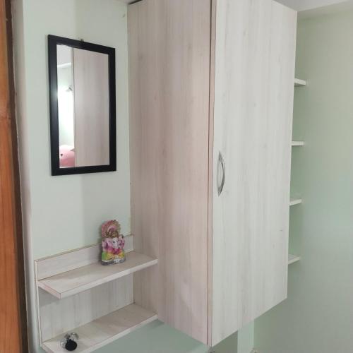 阿加尔塔拉Deep Home stay的浴室设有镜子和带架子的橱柜