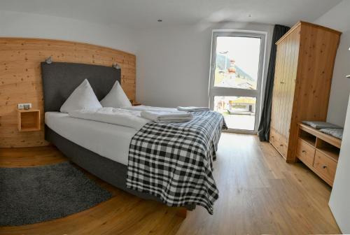 塞尔赖因山谷格里斯Veranda Appartement Bergblick的一间卧室配有一张带黑白毯子的床