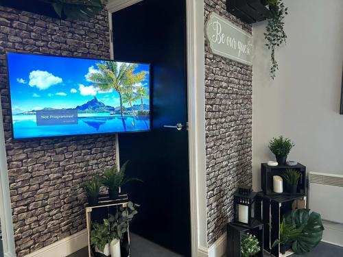 伯明翰Luxury 9ine SUPER BEAUTIFUL JACUZZI APARTMENT WITH BALCONY的挂在砖墙上的电视