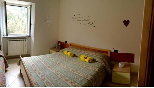 BorzonascaAffittacamere La Quiete的一间卧室配有一张带两个黄色枕头的床