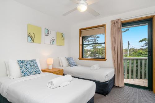 拜伦湾Beach Karma的一间带两张床和窗户的客厅