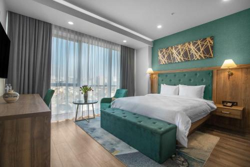 第比利斯Royal Tulip Hotel & Casino, Tbilisi的配有一张床、一张书桌和一扇窗户的酒店客房