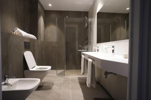 纳瓦雷特Hotel Bodega FyA - GRUPO PIÉROLA的浴室配有2个盥洗盆、卫生间和淋浴。