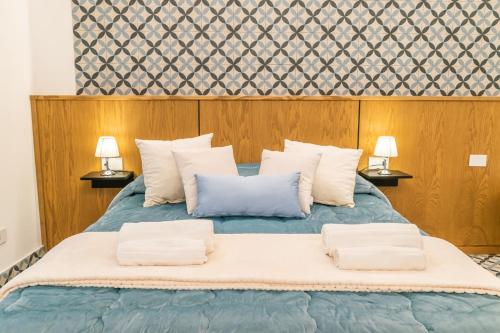 法瓦拉Community Rooms & Wine的一间卧室配有一张带两盏灯的蓝色床。