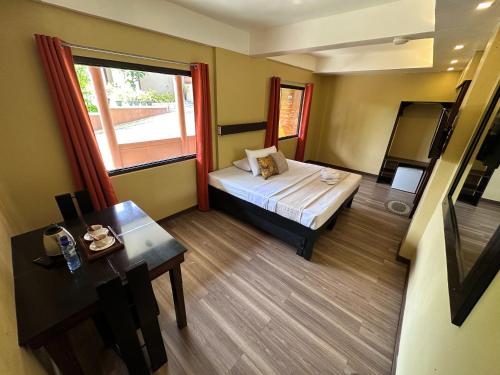 大雅台Piña Colina Resort的客房设有床、桌子和窗户。