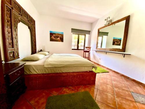 阿索马达Pure La Asomada的一间卧室配有一张床和一面大镜子