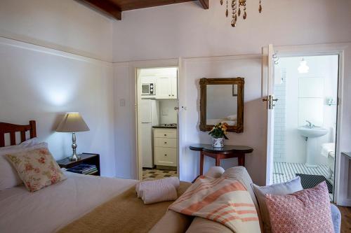 赫曼努斯Eastcliff Cottage的一间卧室配有床、镜子和水槽