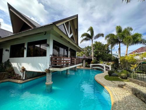 大雅台Piña Colina Resort的房子前面有蓝色的游泳池的房子