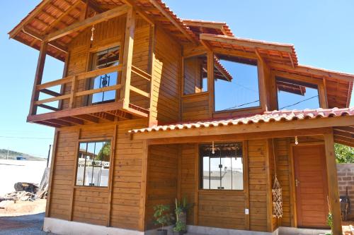 ItapemirimMillicent Residence - Chalet Milly e Chalet Iris - Itaoca Praia - ES的木屋的顶部设有阳台
