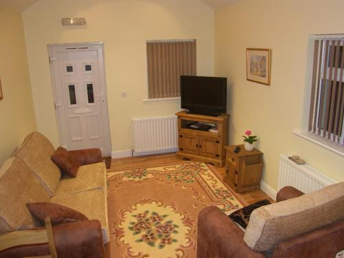 LaxeyPinfold Holiday Cottage的带沙发和电视的客厅