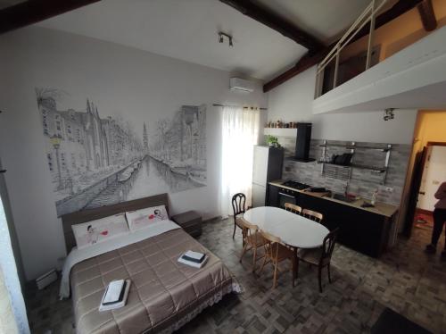 罗马La Badia del Cavaliere 1的一间卧室配有一张床铺和一张桌子,还设有一间厨房