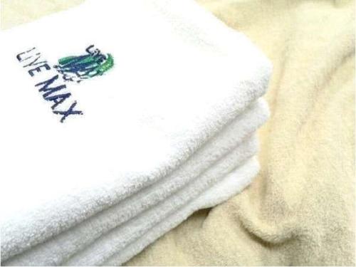 羽村市HOTEL LiVEMAX BUDGET Tokyo Hamura Ekimae的床上的一堆白色毛巾
