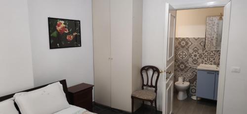 罗马La Badia del Cavaliere 1的一间卧室配有一张床和一把椅子,还有一间浴室