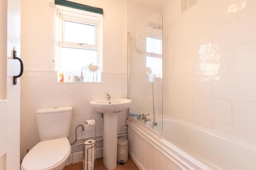 南安普敦Comfortable and convenient stay 3 bed house的浴室配有卫生间、盥洗盆和浴缸。
