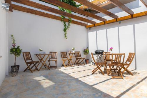普利莫顿Luxury apartments Azalea Primošten的庭院配有椅子和一张带烧烤架的桌子。