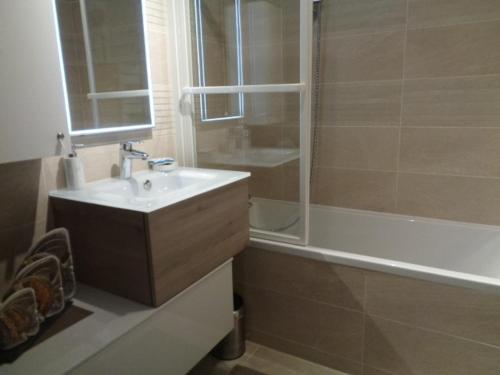 阿卡雄Appartement Arcachon, 3 pièces, 6 personnes - FR-1-374-24的浴室配有水槽、淋浴和浴缸。