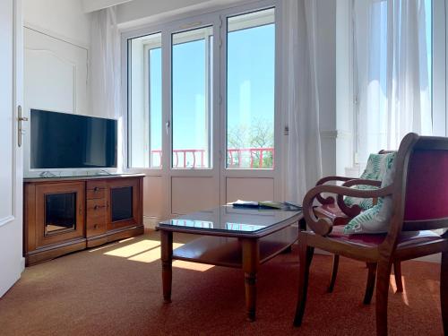 布雷斯特阿巴丽酒店的客厅配有桌子、椅子和电视