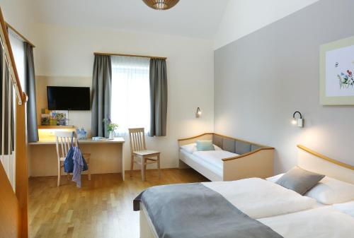 珀劳JUFA Hotel Pöllau - Bio Landerlebnis的酒店客房配有两张床和一张书桌
